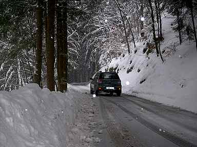 Der Outlander auf einem verschneiten Bergweg - Ansicht von hinten. 