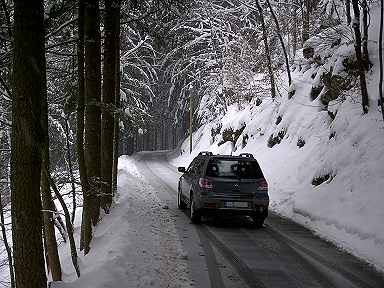 Der Outlander auf einem verschneiten Bergweg - Ansicht von hinten. 